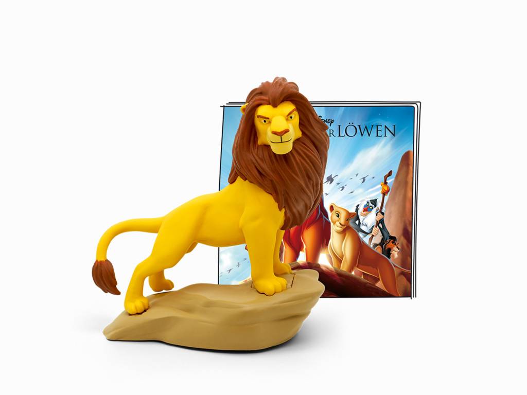 Eine gelbe Löwenfigur mit einer braunen Mähne steht auf einem beigefarbenen Stein vor einem „Der König der Löwen