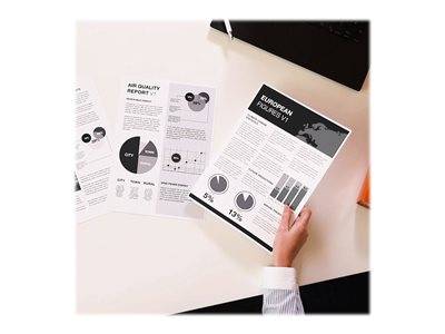 Eine Person überprüft Papierdokumente auf einem Schreibtisch und zeigt Kreis- und Balkendiagramme zu 