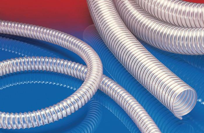 Gewickelte flexible Metallschutzschläuche für Kabel auf einer reflektierenden blau-roten Oberfläche, die industrielles Material oder elektrische Komponenten veranschaulichen.