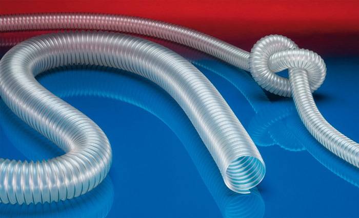 Ein aufgerollter und flexibler transparenter Schlauch wird vor einem kräftigen rot-blauen Hintergrund prominent in Szene gesetzt.