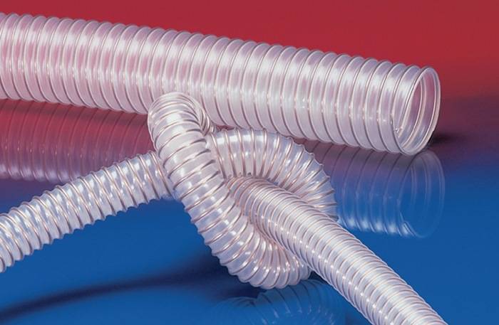Eine flexible, transparente Spiralröhre ruht auf einer reflektierenden Oberfläche mit einem Hintergrund in Rot- und Blauabstufungen.