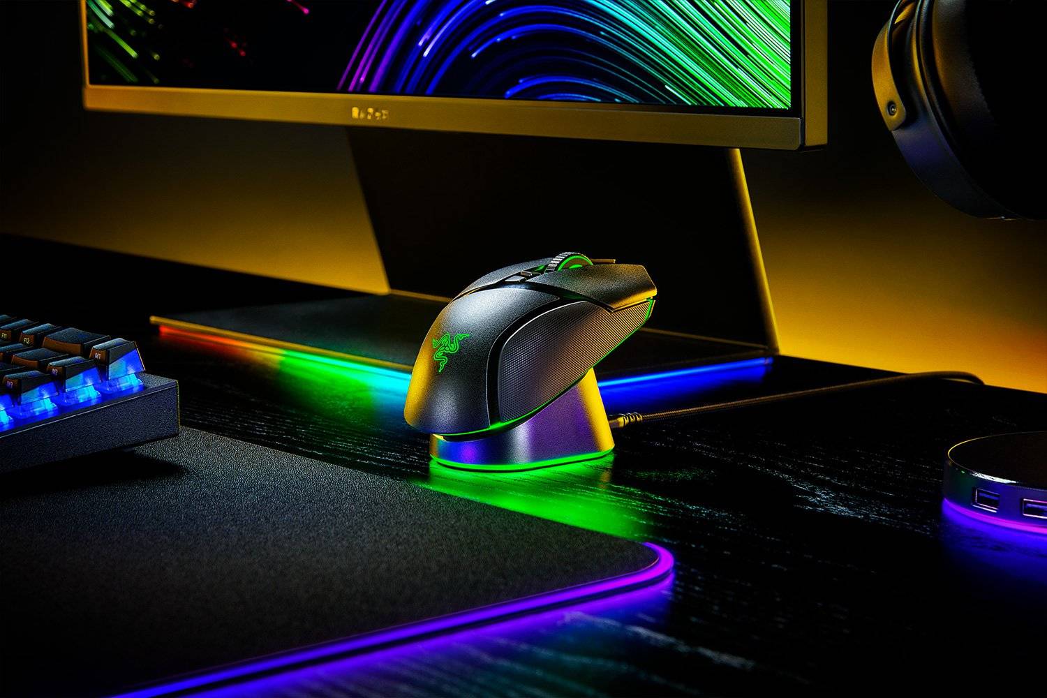 Eine RGB-beleuchtete Gaming-Maus auf einem Schreibtisch unter einem Monitor, mit Tastatur und Kopfhörern in der Nähe, in einer dunklen Neon-Gaming-Umgebung.