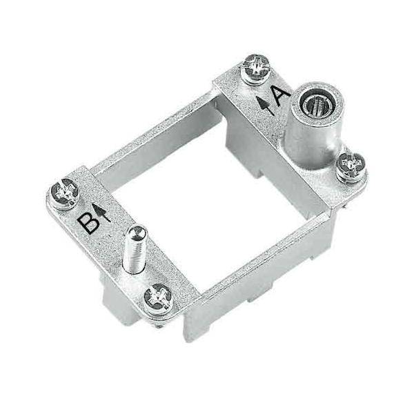 Eine Metallhalterung mit vier Schraublöchern, beschriftet mit '1A' und 'B1', die für die Befestigung von elektronischen Komponenten oder Geräten konzipiert ist.