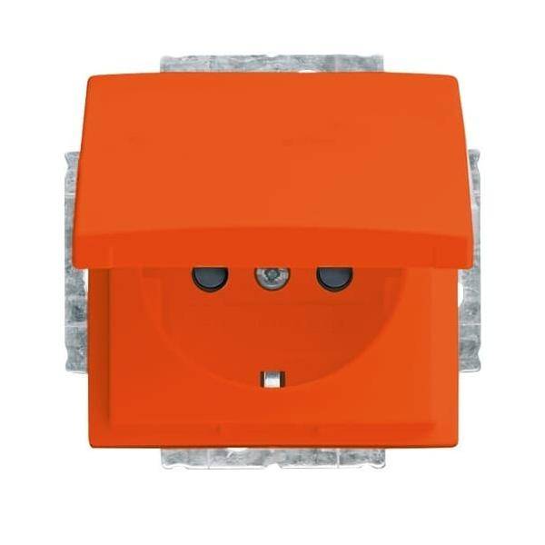 Eine helle orangefarbene Steckdose mit zwei kreisrunden Öffnungen und einem Erdungsbolzenschlitz, teilweise verdeckt, vor einem weißen Hintergrund.