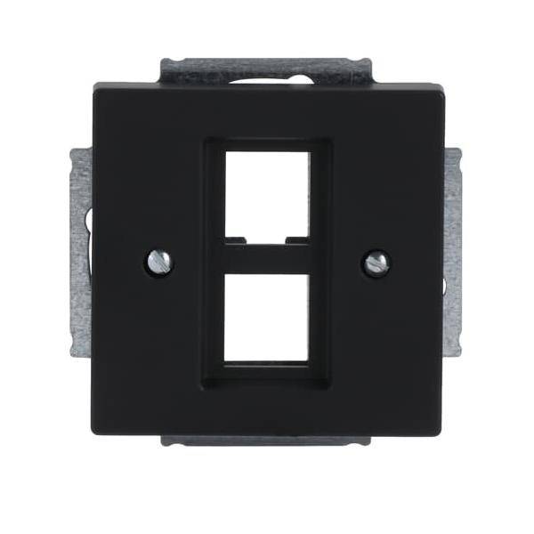 Eine schwarze Wandabdeckung mit zwei rechteckigen Öffnungen, konzipiert für die Aufnahme von Steckdosen oder Schaltern, montiert auf einem Metallbefestigungswinkel.