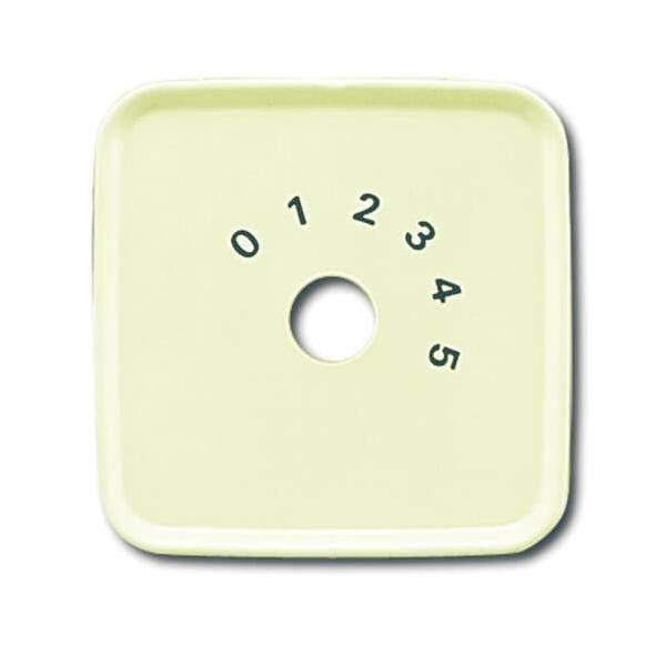 Ein quadratisches gelbes Zifferblatt mit einem zentralen Loch, umgeben von Zahlen von 0 bis 5 in einem Halbkreis an der Oberseite.