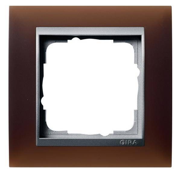 Ein quadratischer, brauner Schalter- oder Steckdosenrahmen mit einem metallischen Innenborder. Die Mitte ist leer und bereit für die Installation eines Schalters oder einer Steckdose.