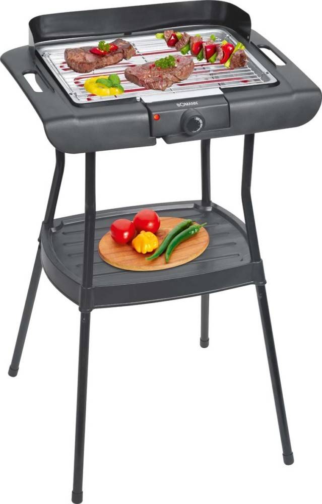 Ein elektrischer Grill mit verschiedenen Gemüsesorten wie Tomaten, Mais und Paprika auf dem Grillrost, und weitere frische Gemüsesorten auf einem Holzbrett darunter.