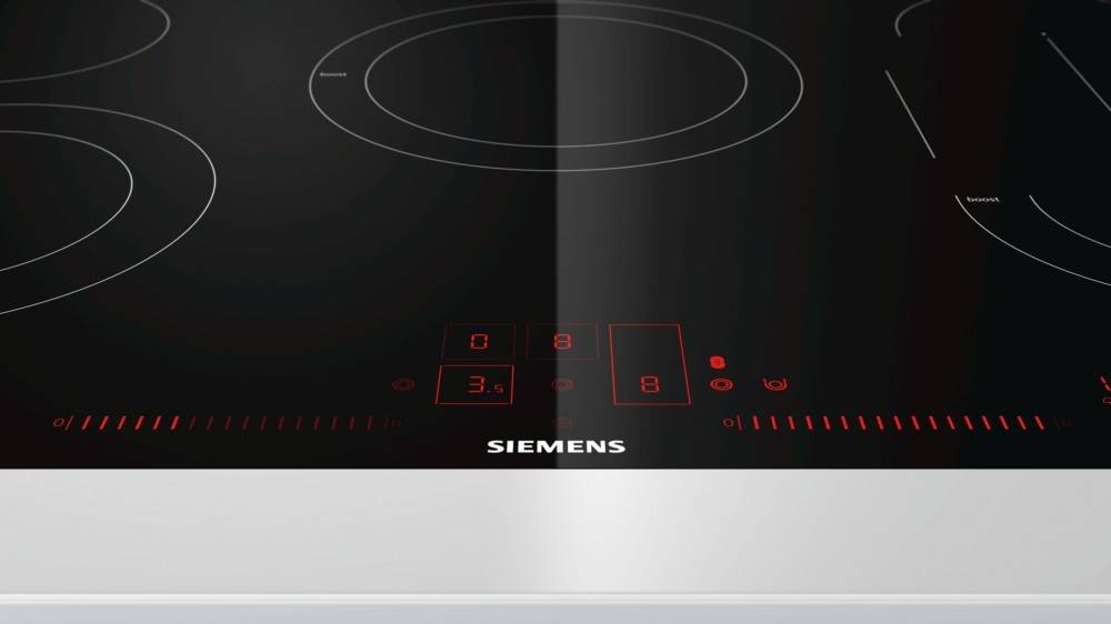 Induktionskochfeld mit einem digitalen Bedienfeld, das Heizstufen anzeigt. Die Oberfläche ist schlicht und schwarz mit einem Siemens-Logo unterhalb des Displays.