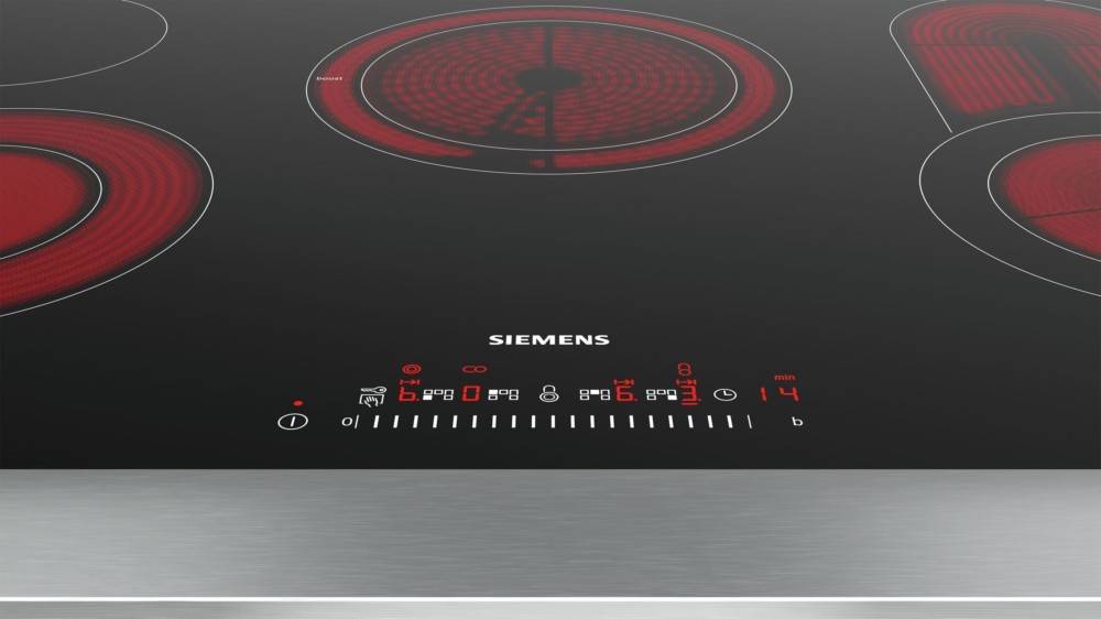 Elektroherd mit rot leuchtender Induktionszone und digitaler Anzeige. Siemens-Logo sichtbar. Bedienelemente zeigen Heizstufen und Timer.