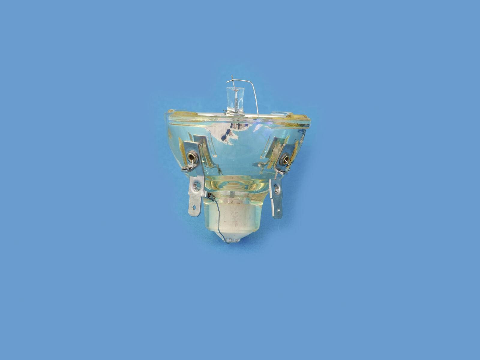 Klare Projektorlampe vor blauem Hintergrund. Die Lampe verfügt über sichtbare Glühdrähte und Metallhalterungen zur Befestigung.