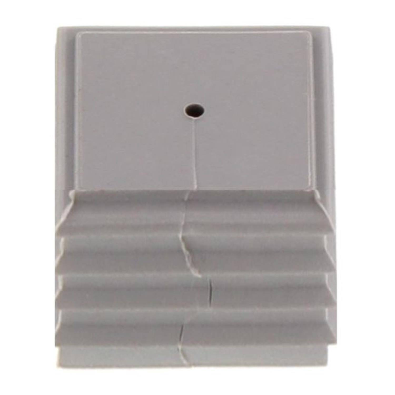 Ein kleines, graues rechteckiges Objekt mit einem zentralen Loch und einer strukturierten Oberfläche, das drei horizontale Rippen auf der unteren Hälfte aufweist.