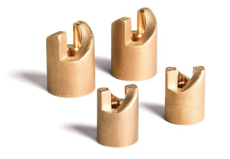 „Vier goldfarbene elektrische Stecker mit U-förmigen Öffnungen auf weißem Hintergrund.