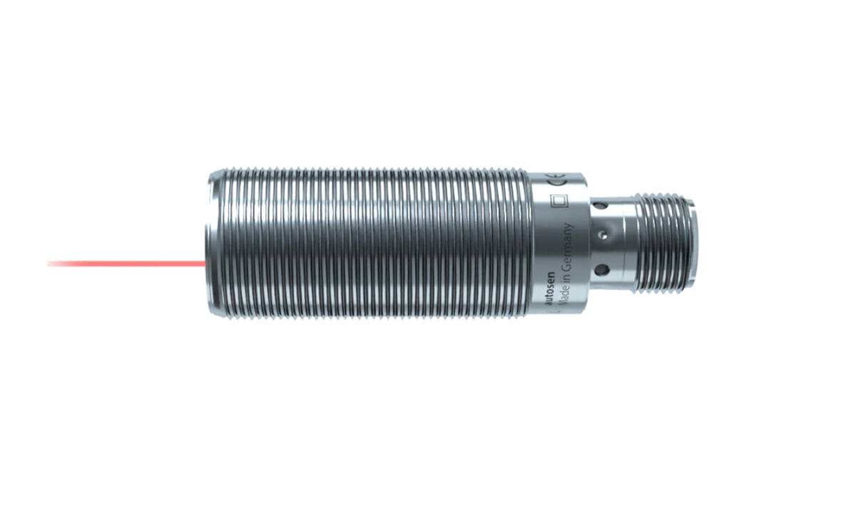 Ein zylindrischer Industriesensor mit gerippter Metalloberfläche sendet einen roten Laserstrahl von einem Ende aus.