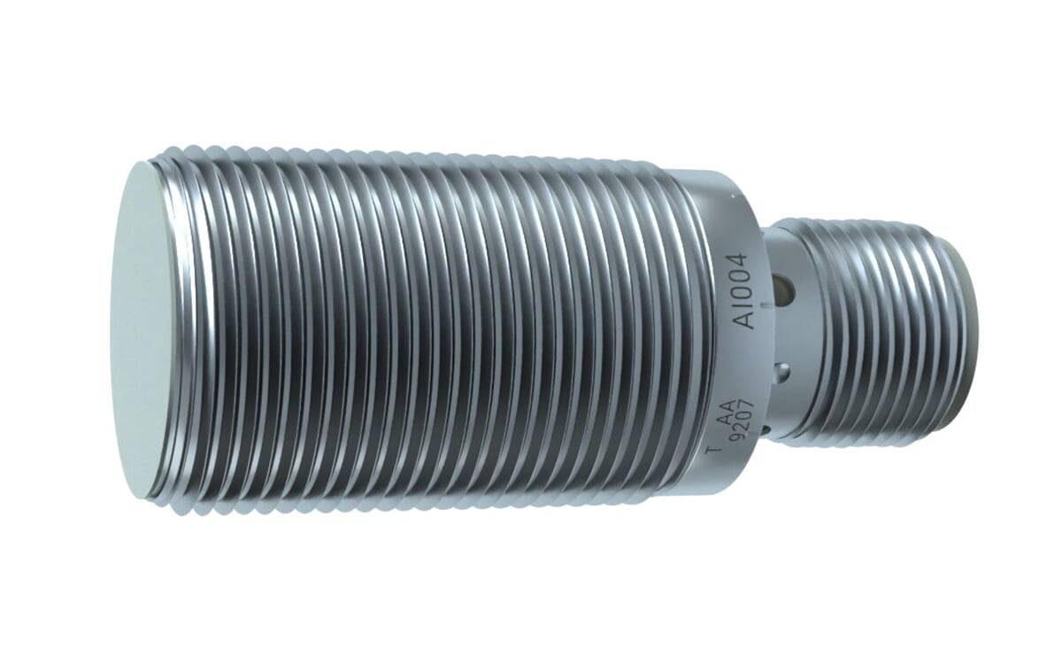 Eine silberne metallische Faltenausgleichsverbindung mit geripptem Design, beschriftet mit 'T AA 9207 A1004'. Sie ist zylindrisch und gewellt.