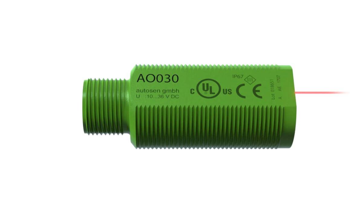 Grüner elektronischer Sensor mit Gewinde, beschriftet mit 'AO030', versehen mit Zertifizierungssymbolen, IP67-Schutzart und Spannungsinformationen.