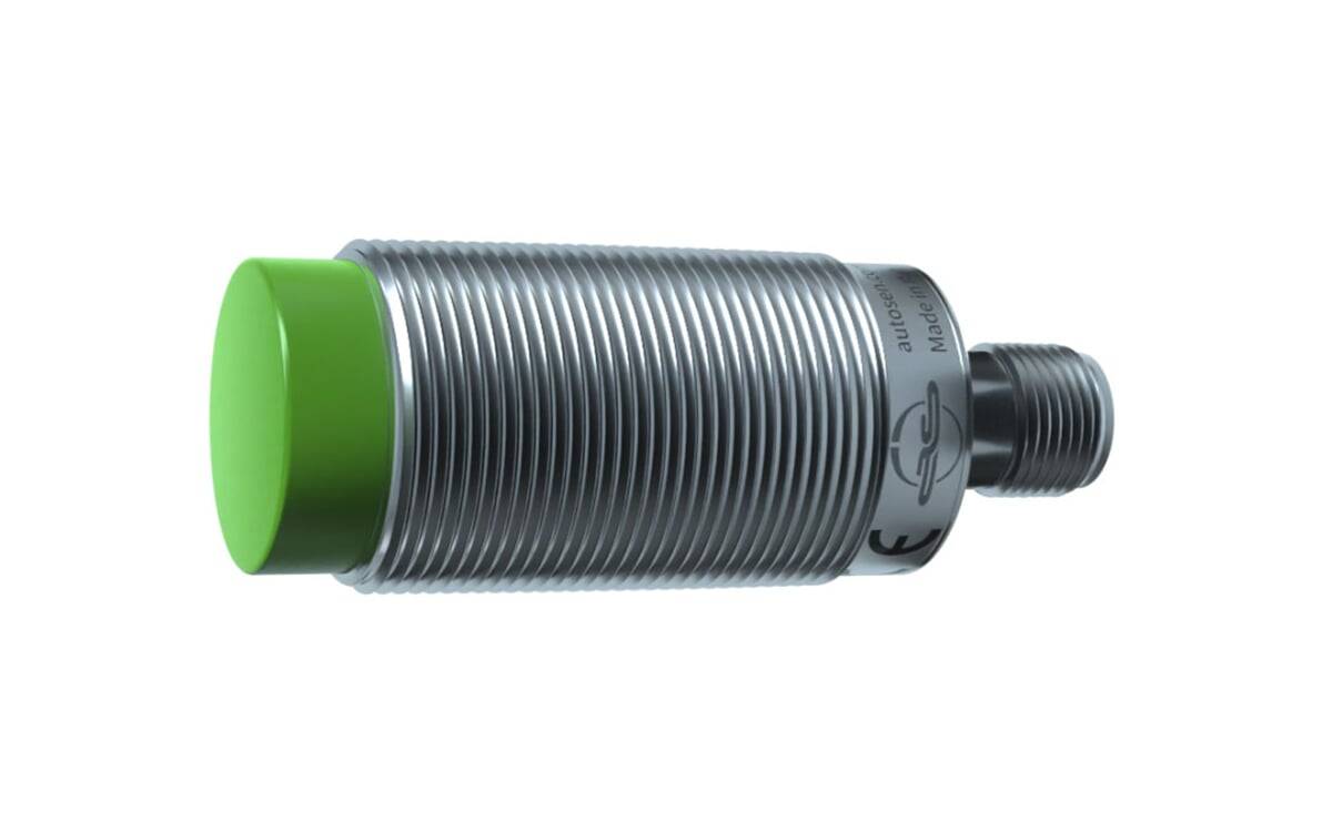 Ein zylindrischer Metallsensor mit einer grünen Kappe, verwendet zur Objekterkennung, mit gerippter Gestaltung für besseren Griff und Langlebigkeit.