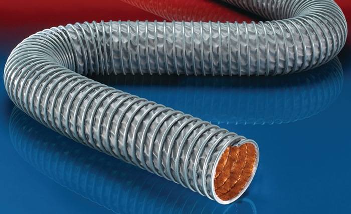 Eine Nahaufnahme von zwei aufgewickelten Metallschläuchen auf einer blauen und roten Oberfläche, die ihr flexibles, geripptes Design zur Geltung bringt.