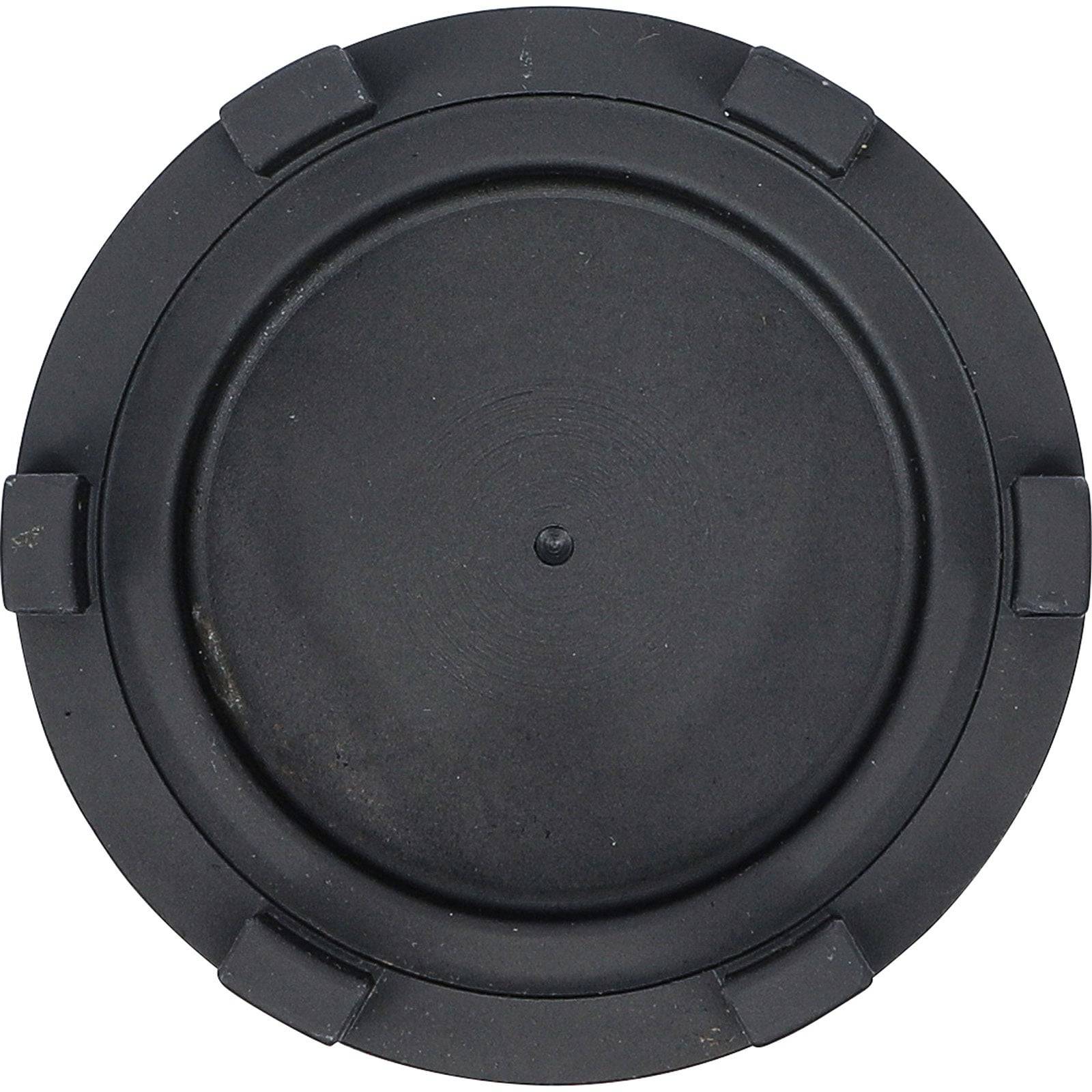 Eine kreisförmige schwarze Objektivkappe mit sechs kleinen Laschen am Rand, die zum Schutz von Kameraobjektiven verwendet wird.