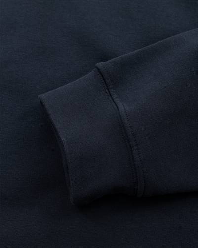 Eine Nahaufnahme eines dunkelblauen Sweatshirt-Ärmels mit sauber genähten Nähten, die die Gewebetextur und Qualität zur Geltung bringt.