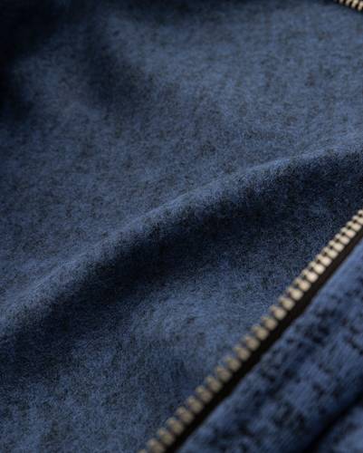 Nahaufnahme eines blauen Filzstoffs mit sichtbarer Textur, die Licht- und Schattendetails zeigt.