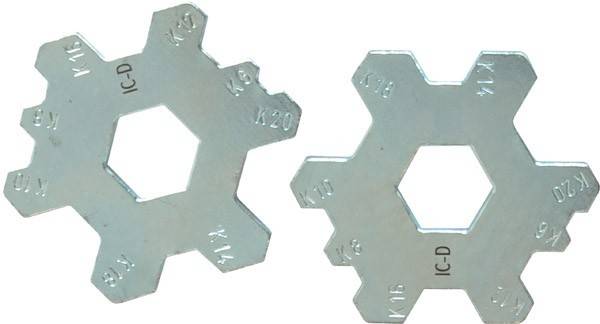 Ein Metallmesswerkzeug mit sechseckigen Aussparungen, die mit verschiedenen Zahlen beschriftet sind und zur Größenmessung von Objekten verwendet wird.