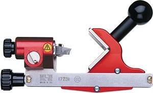 Nahaufnahme eines roten Schneid- oder Befestigungswerkzeugs mit einem Warnzeichen auf einer Metallkomponente, die industrielle Ausrüstung hervorhebt.