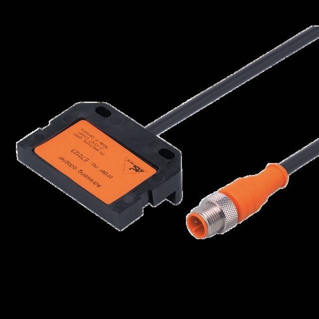Ein orange-schwarzer elektrischer Sensor mit einem Steckverbinder, beschriftet mit 'Identsysteme Group' und '10-30V DC Ind.'.