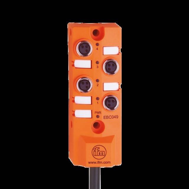 Ein orangefarbenes industrielles Sensormodul mit vier nummerierten Anschlussports und einer PWR-Anzeige, versehen mit dem Logo und der URL 