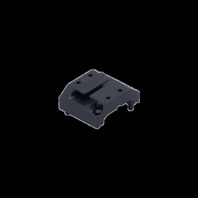 Ein kleines, schwarzes Plastikteil mit Rillen und Löchern, wahrscheinlich eine Komponente für den Zusammenbau oder die Befestigung in einer größeren mechanischen Struktur.