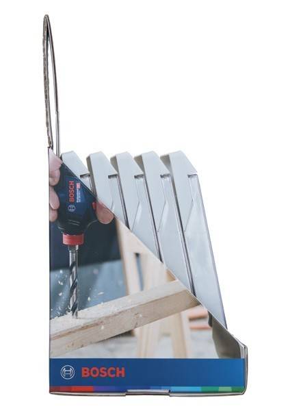Eine Hand benutzt einen Bosch-Akkuschrauber, um Löcher in ein Holzbrett zu bohren, mit Haufen von Holzspänen drumherum, die eine laufende Holzbearbeitung zeigen.
