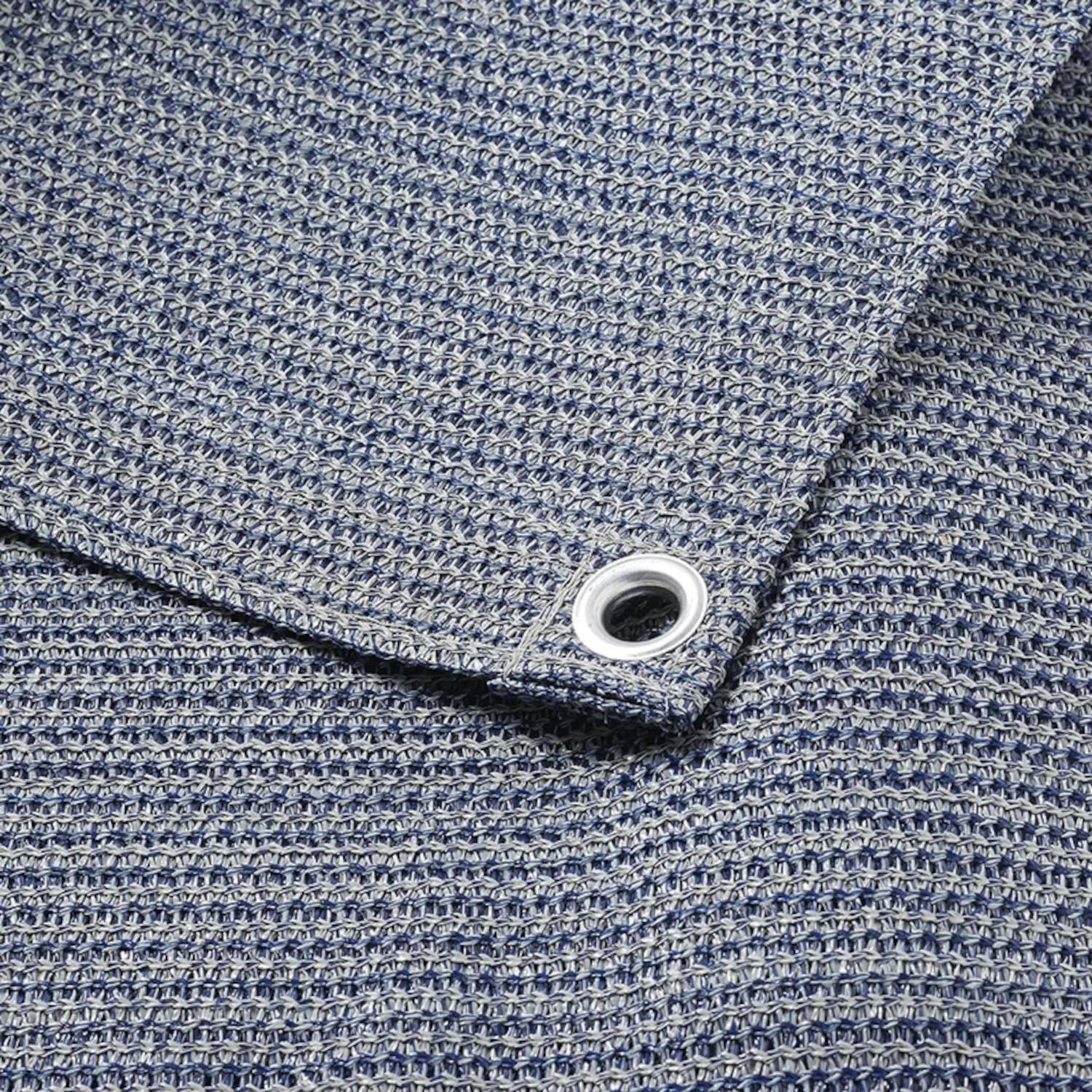 Eine Nahaufnahme eines blauen strukturierten Stoffes mit einem Metallöse in der Ecke, die das Webeumuster und Nähdetails zeigt.