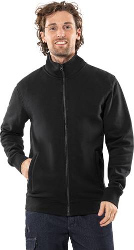 Eine Person trägt eine schwarze Jacke mit Reißverschluss und hat die Hand in einer Tasche, vor einem einfarbigen schwarzen Hintergrund.