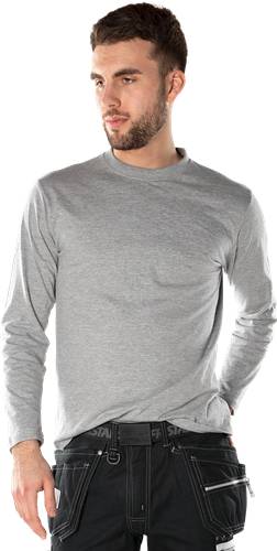 Eine Person, die ein schlichtes graues Langarmshirt vor einem schwarzen Hintergrund trägt, mit entspannt herabhängenden Armen.