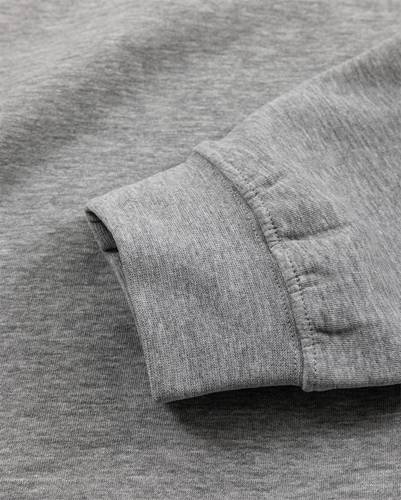 Eine Nahaufnahme zeigt den Ärmelabschluss eines langärmeligen Shirts aus grauem, gestricktem Stoff, wobei Textur und Nahtnähte hervorgehoben werden.