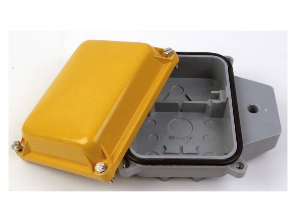 Eine offene gelbe Verteilerdose mit grauer Basis, die interne Fächer zeigt. Verwendet für Elektroverkabelungsschutz und -organisation.