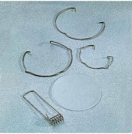 Chirurgische Cochlea-Implantat-Komponenten, die auf einer hellblauen Oberfläche ausgelegt sind, einschließlich Kabel, Spulen und einer transparenten Scheibe.