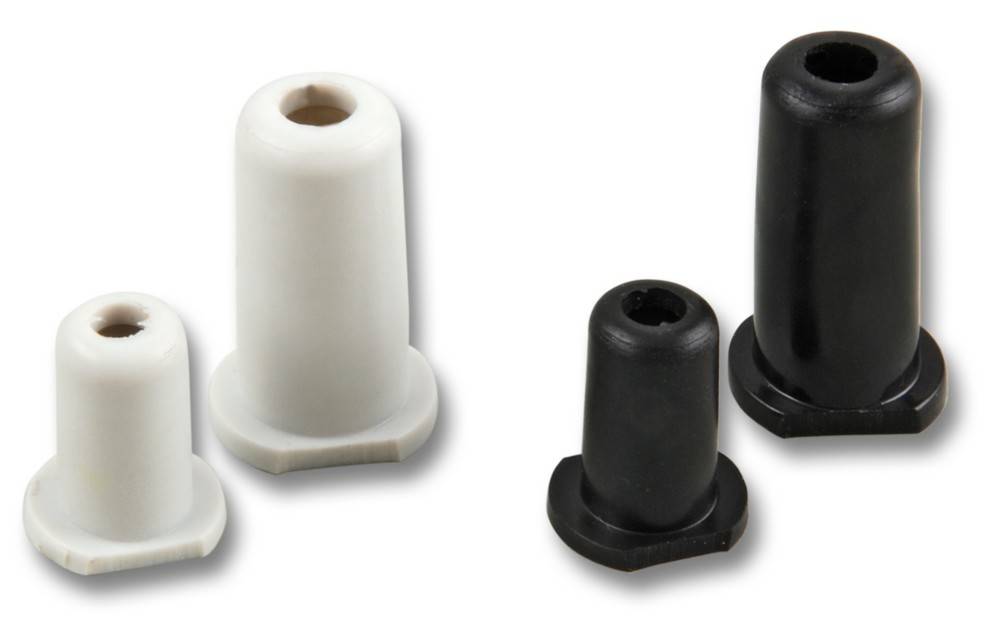 Zwei weiße und zwei schwarze Kunststoff-Abstandshalter mit röhrenförmiger Gestalt und verbreiterter Basis, aufrecht auf einem einfarbigen Hintergrund positioniert.