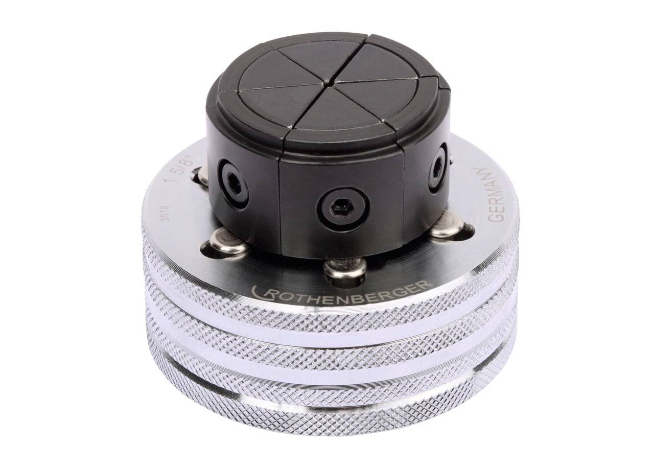 Nahaufnahme eines Rothenberger-Rohwerkzeugs mit einer schwarzen, kreisförmigen Klemme auf einer strukturierten Metalloberfläche, das für sanitärtechnische Anwendungen verwendet wird.