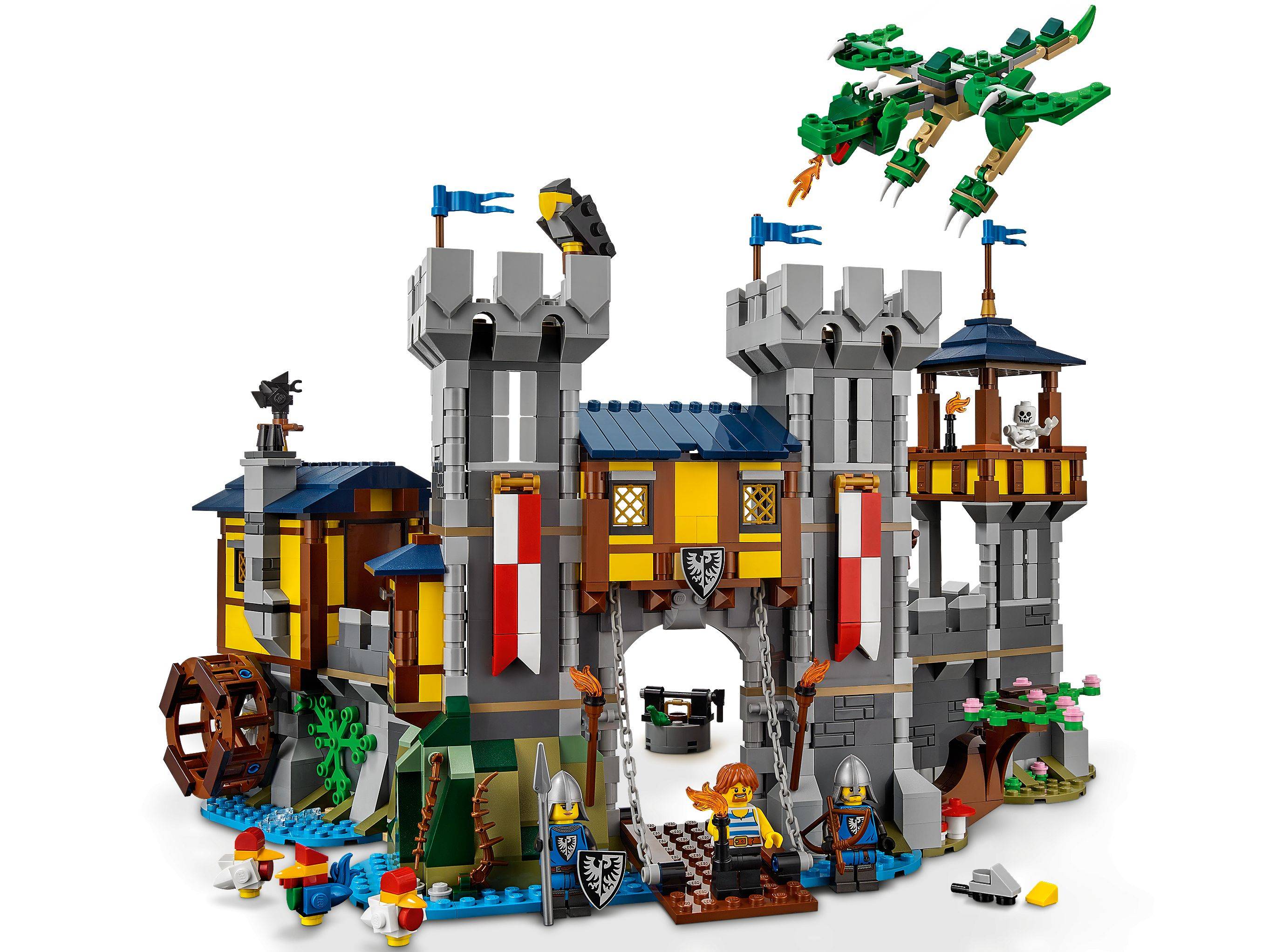 LEGO Mittelalterburg mit zwei grauen Türmen, einem Zugbrückeneingang, einem Wasserrad, Minifiguren und einem fliegenden grünen Drachen darüber.