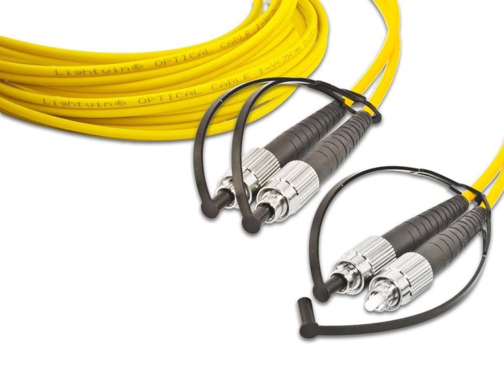 Gelbe Lichtwellenleiterkabel mit schwarzen und silbernen Steckverbindern auf weißem Hintergrund, in Schleifen angeordnet.