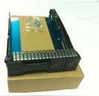 Eine Festplatte in einem schwarzen Gehäuse ruht auf einem Karton, mit kleinen Hardwarekomponenten in einer Plastiktüte oben auf dem Laufwerk.