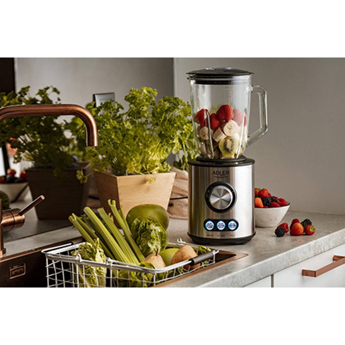 Ein Mixer auf einer Küchentheke gefüllt mit Obst neben frischem Gemüse, was die Zubereitung eines gesunden Smoothies andeutet.