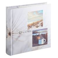 Ein weißes Fotoalbum oder Sammelalbum mit einem Blumencover, auf der Vorderseite zwei kleine Landschaftsfotos und das Wort 