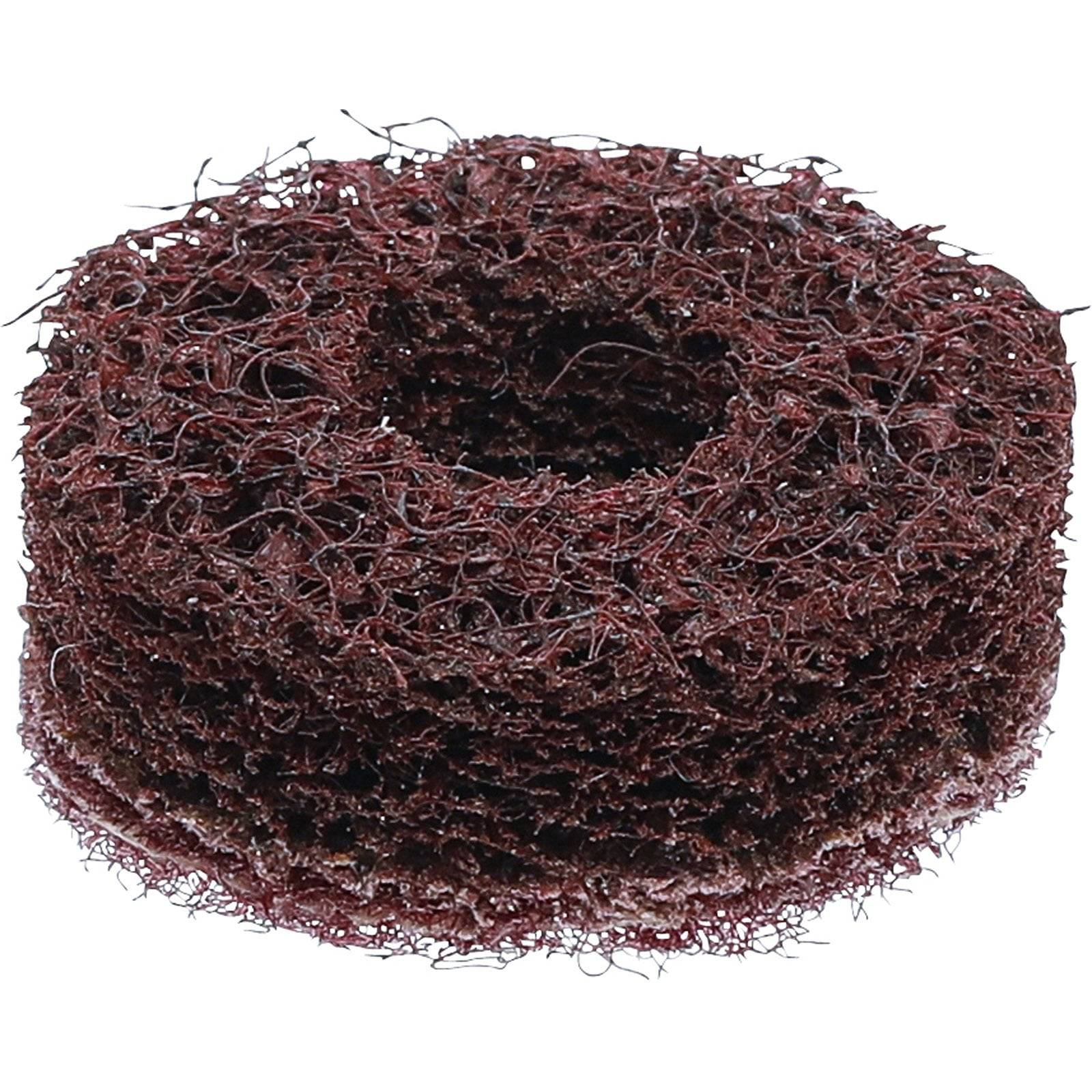 Ein rundes, braunes Scheuertuch mit einem Loch in der Mitte, das zum Reinigen und Schrubben von Oberflächen verwendet wird.