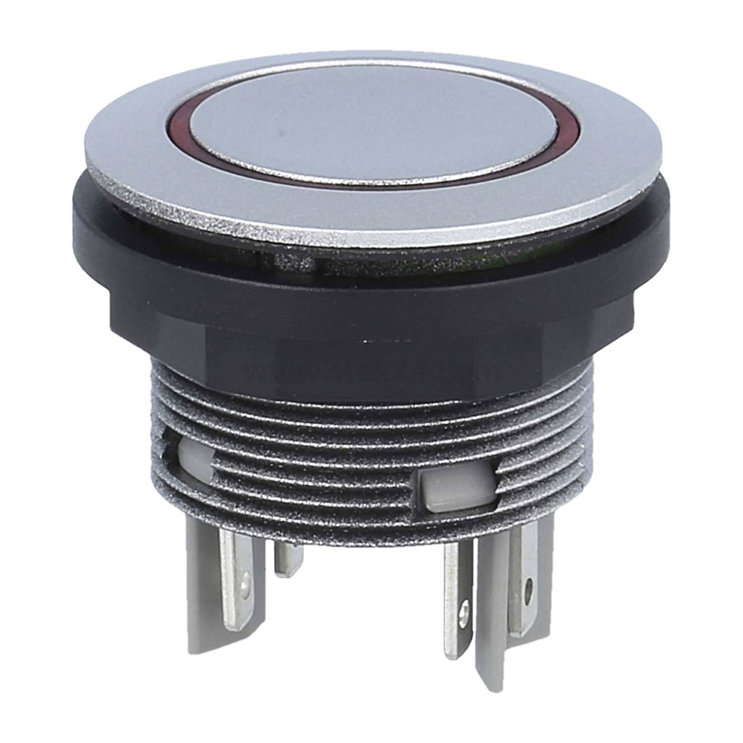 Ein Nahaufnahmefoto eines kreisförmigen, metallischen Druckknopfschalters mit einer schwarzen Kunststoffbasis und mehreren Metallzacken an der Unterseite.