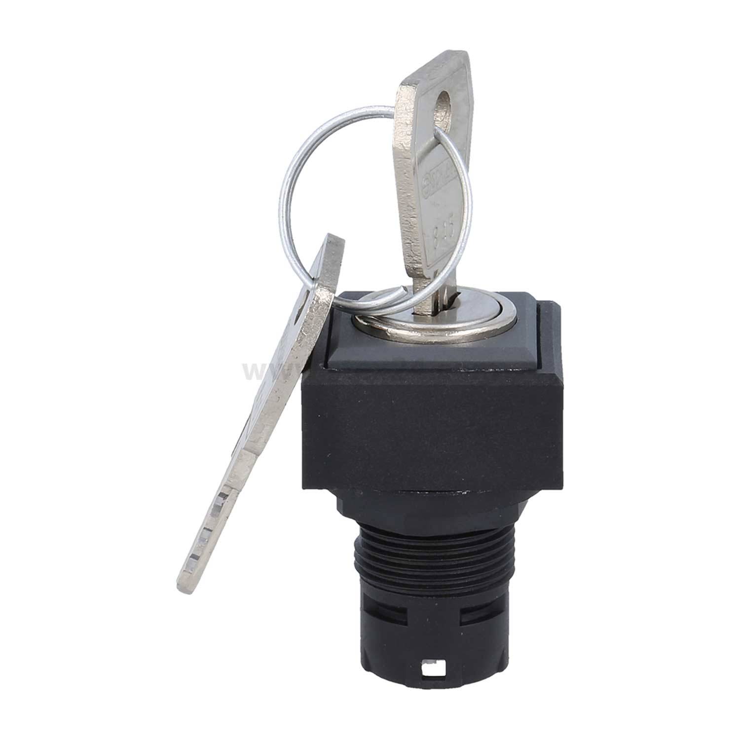 Ein Metallschlüssel, der in einen quadratischen schwarzen Zündschalter mit angebrachtem Schlüsselanhänger eingeführt ist.