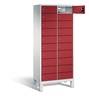 Rotes Metallspindschrank mit vielen kleinen Schubladen und einem oberen Fach auf weißem Hintergrund.