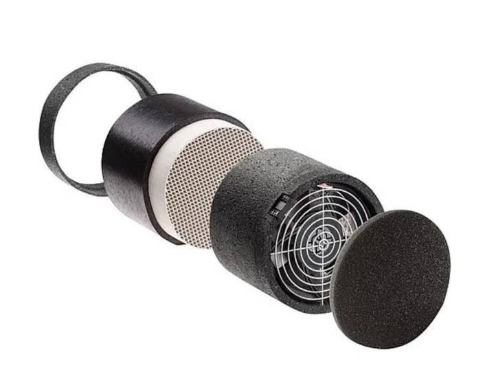 Ein zerlegter Luftfilter, der seine Komponenten zeigt: einen zylindrischen Filter, ein Metallgitter und eine runde Abdeckung.