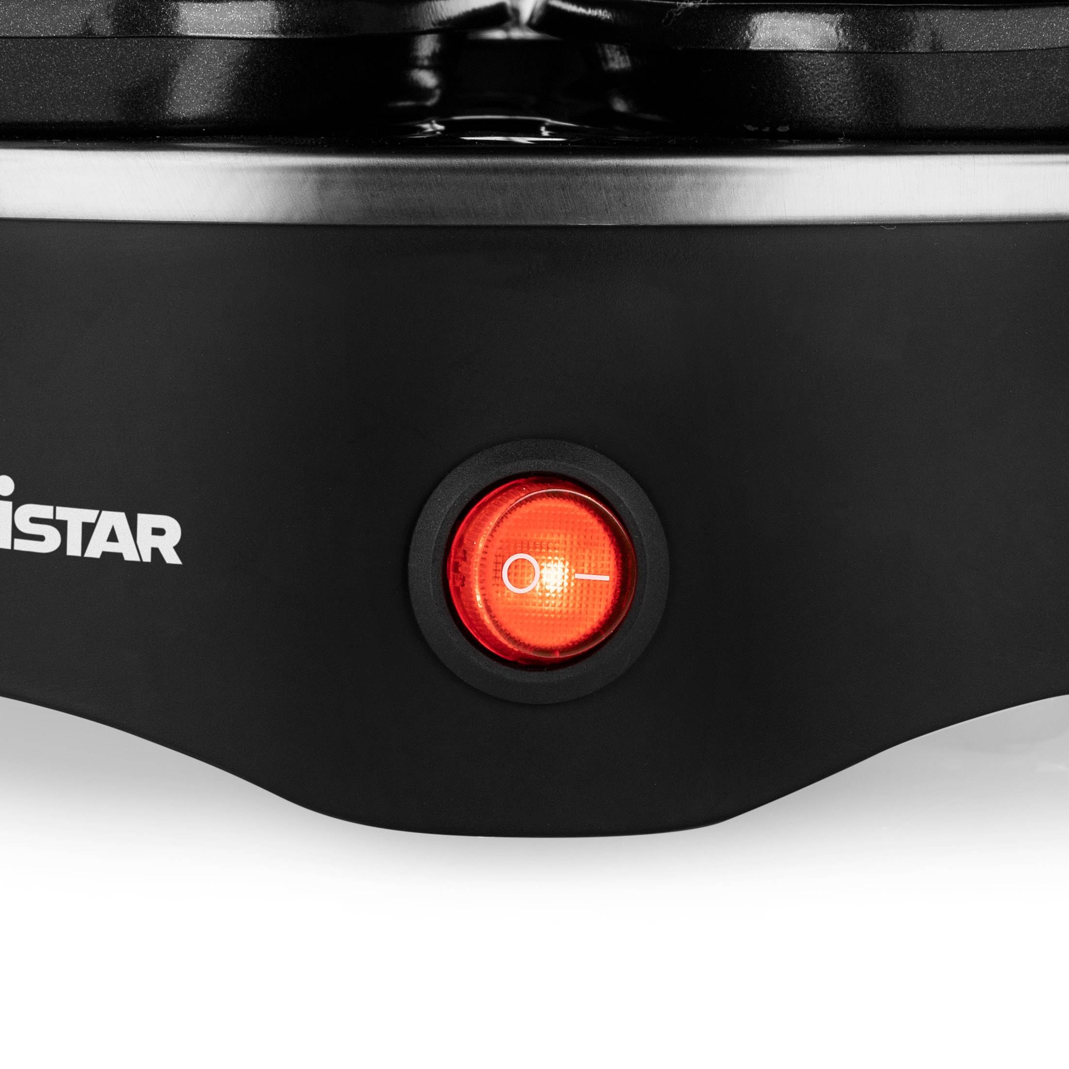 Nahaufnahme eines schwarzen Geräts mit einem leuchtenden roten Netzschalter und teilweise sichtbarem "STAR""-Logo.